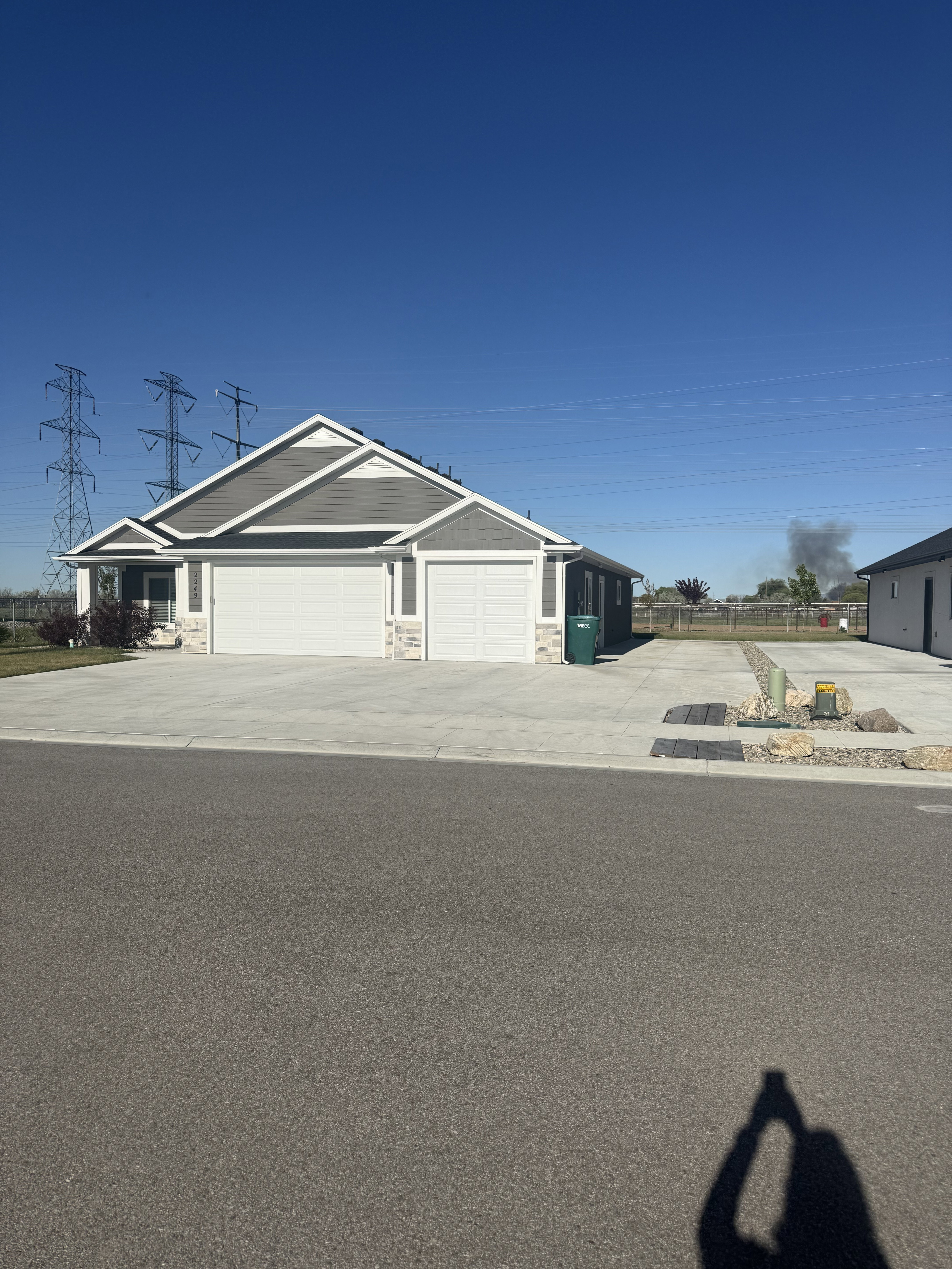 Single story home featuring stone siding, an attached garage, and concrete driveway