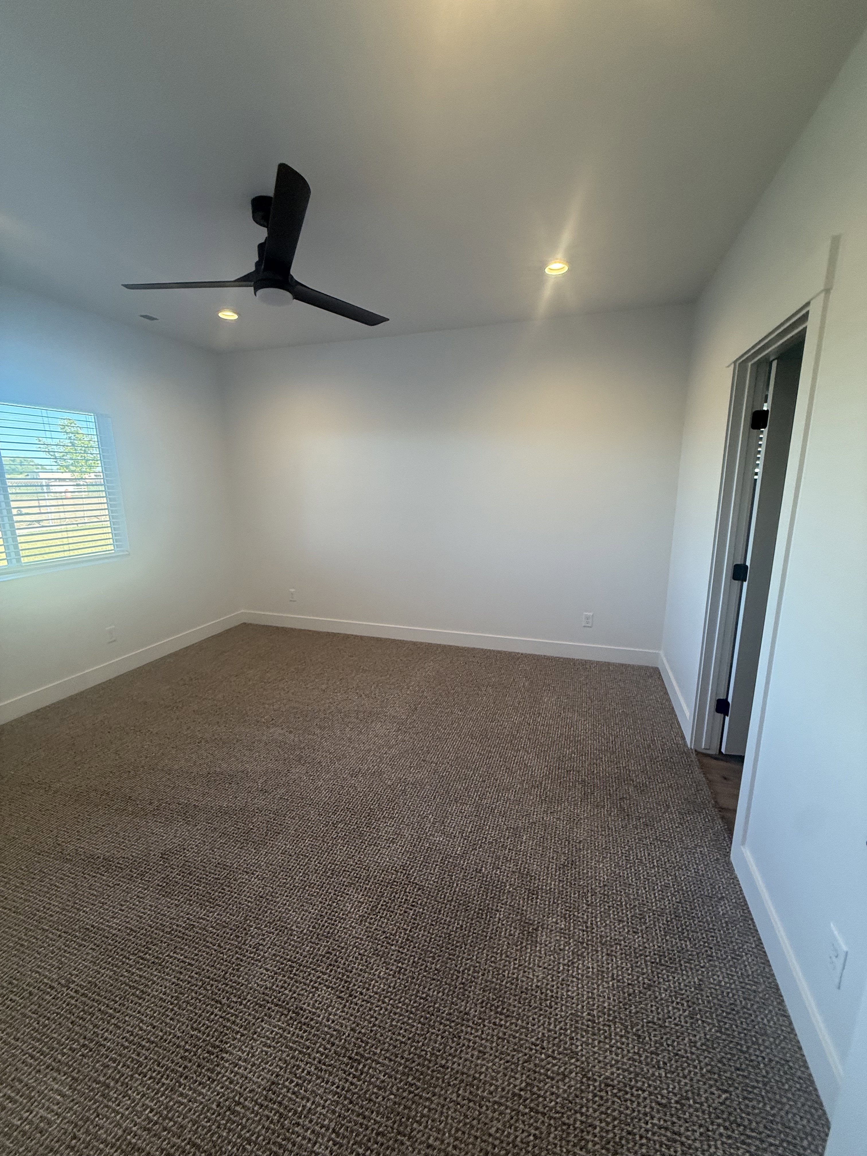 Unfurnished room with dark carpet, ceiling fan, and recessed lighting