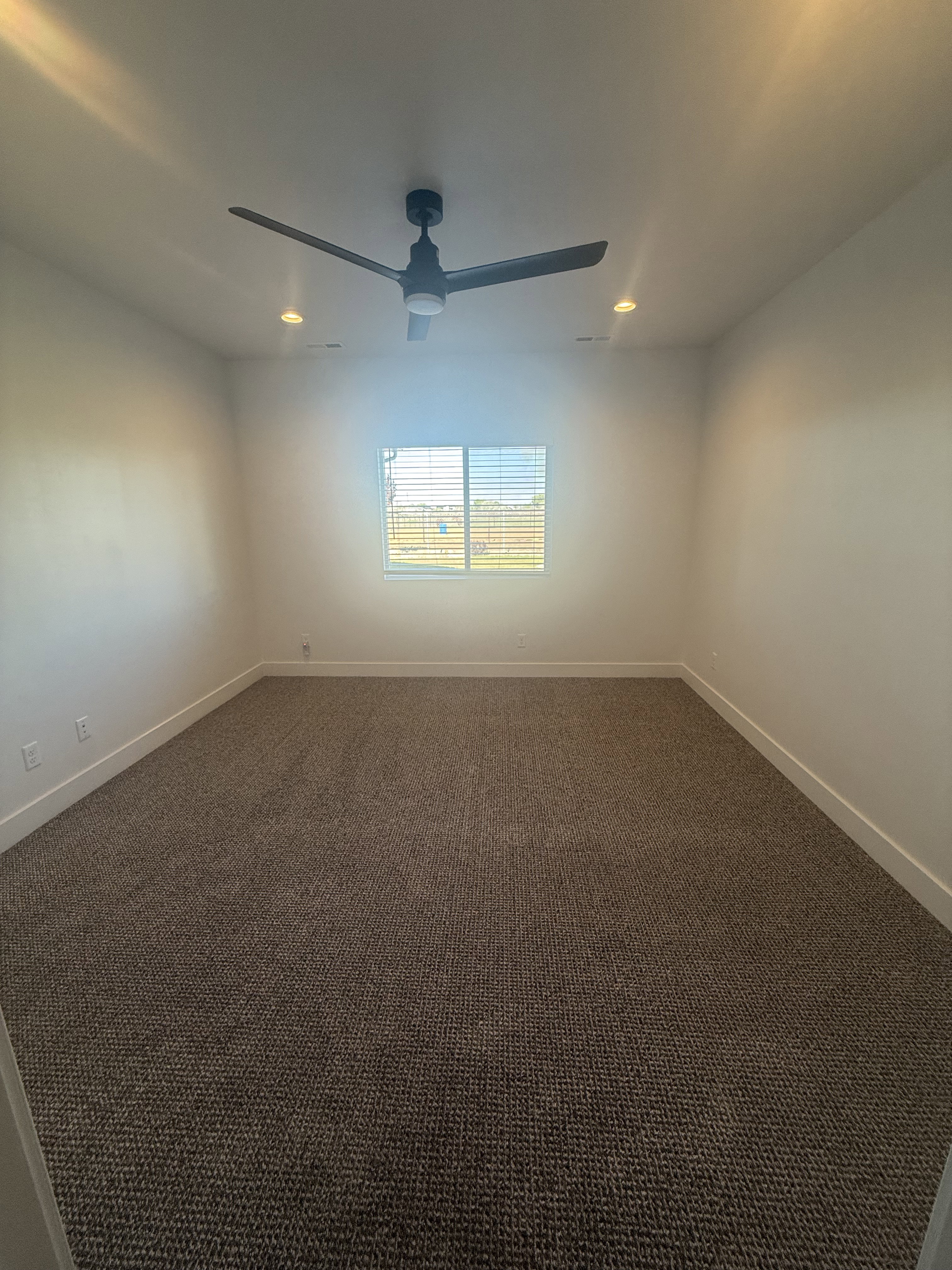 Spare room with dark carpet, recessed lighting, and a ceiling fan