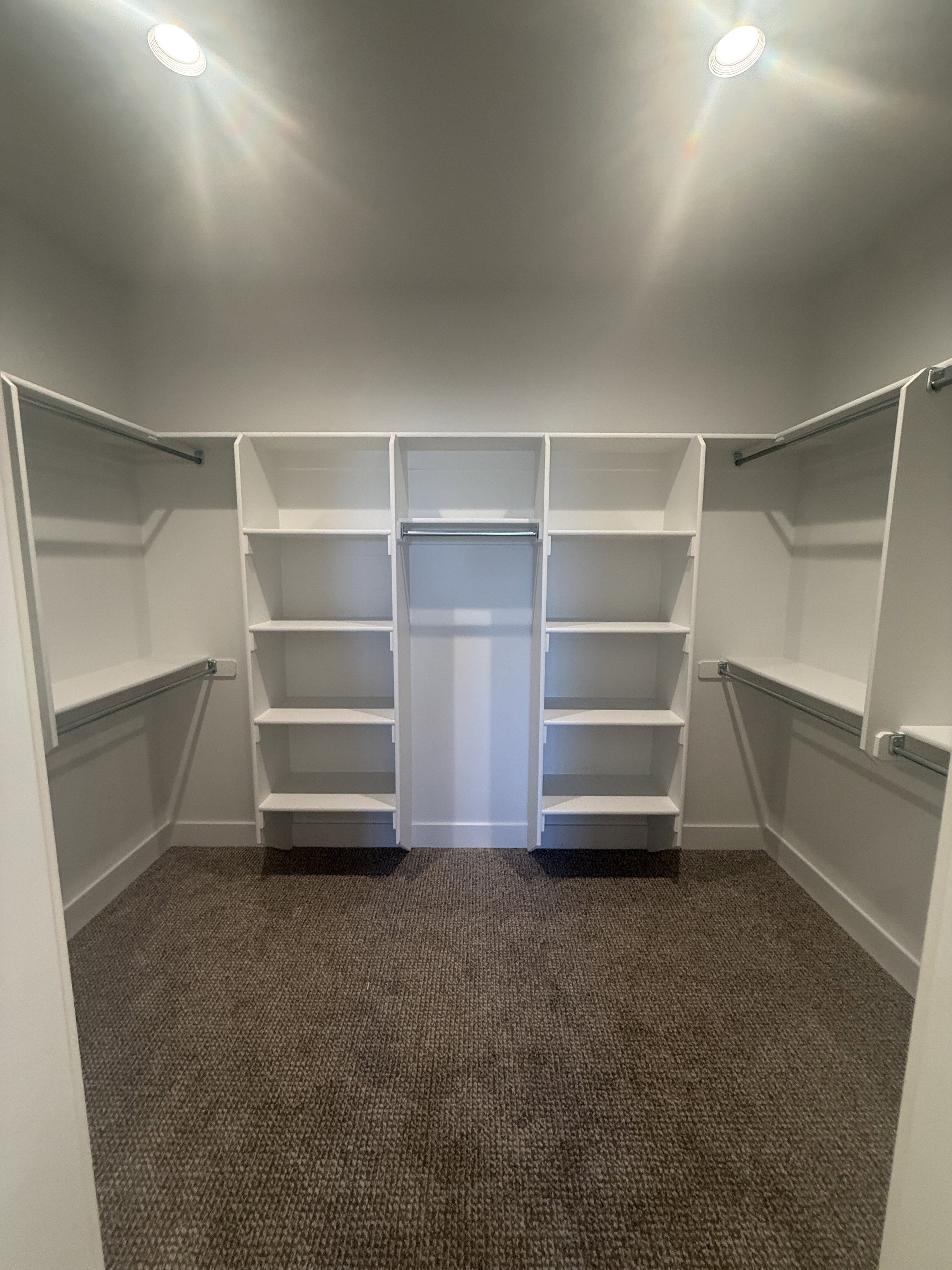 Walk in closet featuring dark carpet