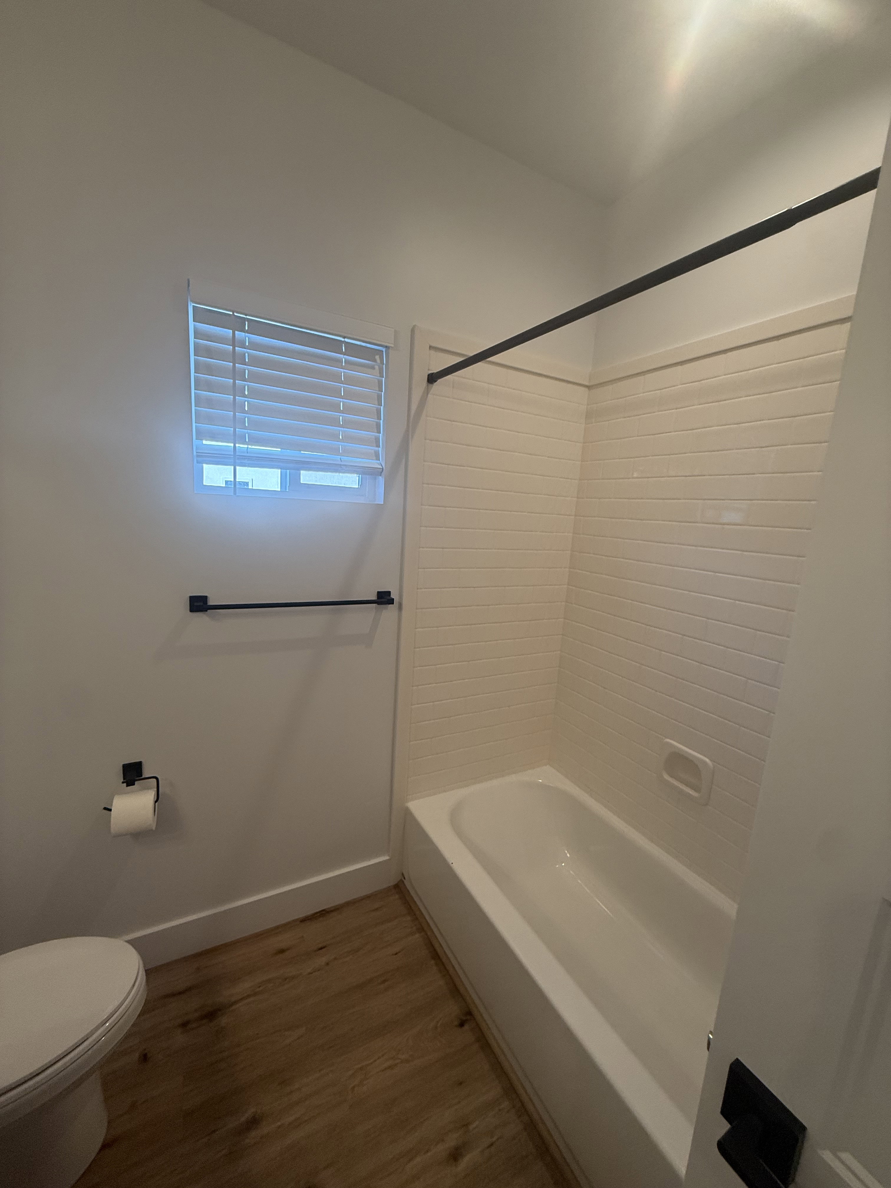 Full bath featuring dark wood-style flooring and bathtub / shower combination