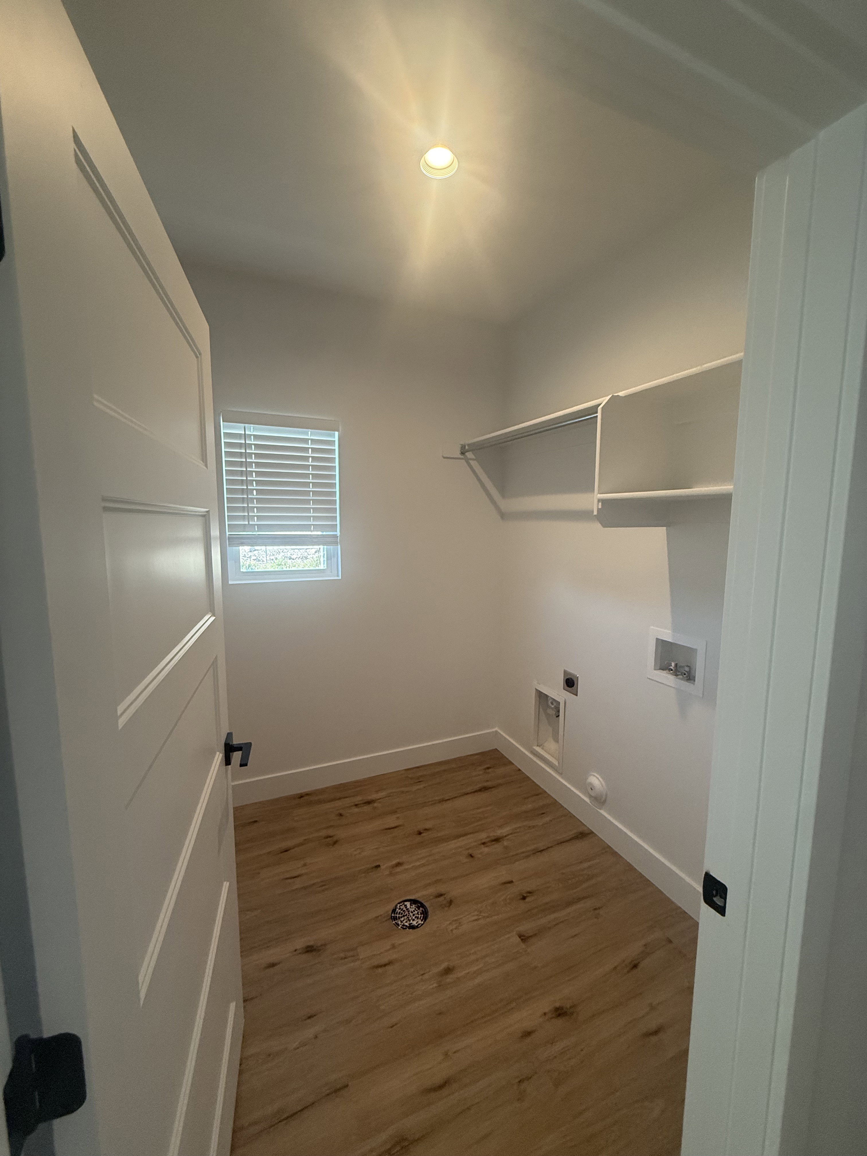 Laundry room with dark wood finished floors, washer hookup, and electric dryer hookup