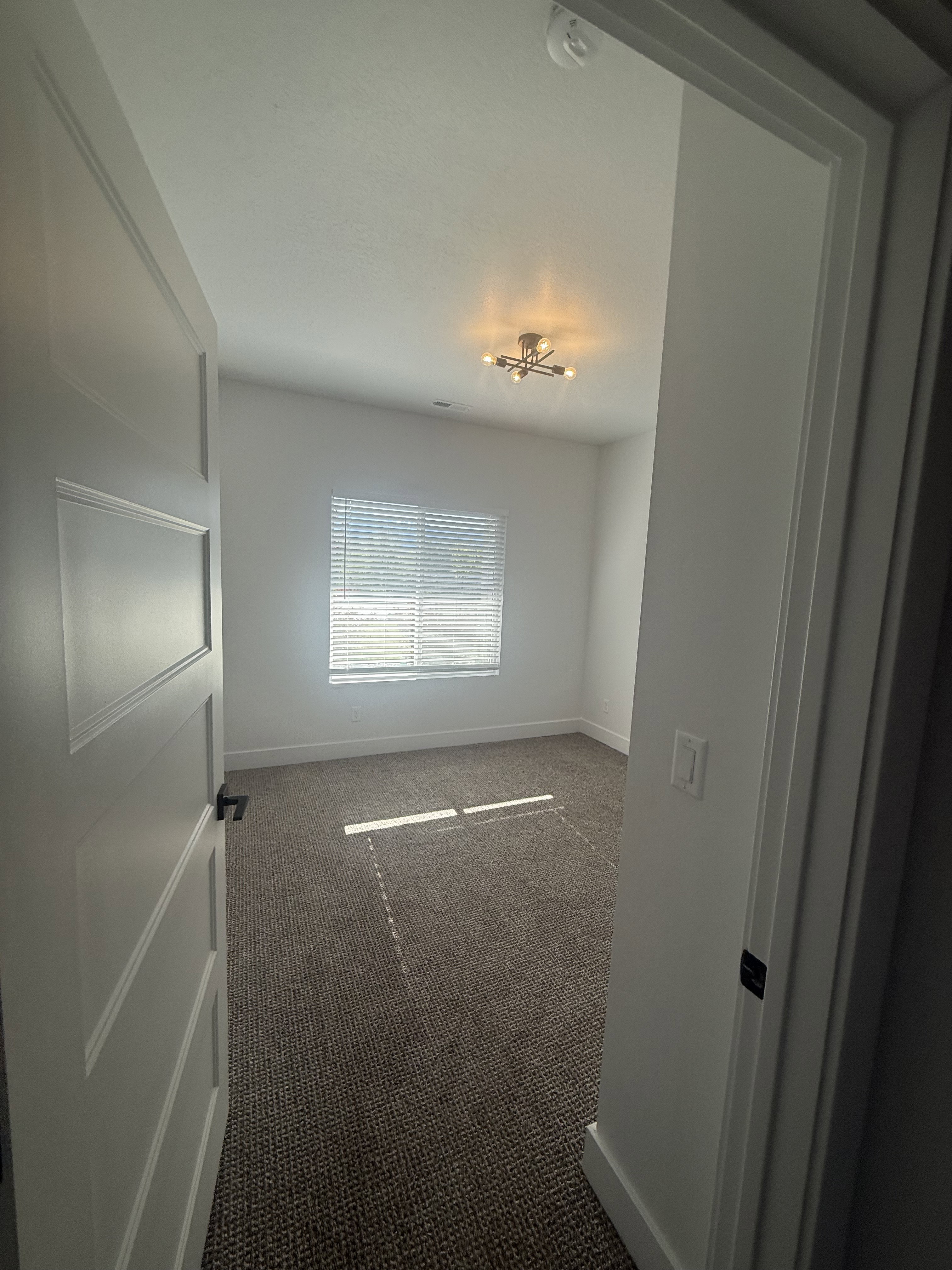 Unfurnished room with carpet and a smoke detector