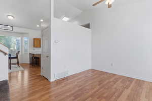 Unfurnished room with vaulted ceiling, light wood-type flooring, and ceiling fan