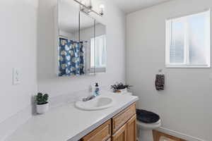 Bathroom with vanity, curtained shower, and light wood-style flooring
