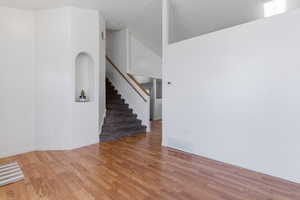 Unfurnished living room featuring a high ceiling and light wood-style flooring