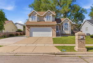 Traditional-style house with driveway, roof with shingles, brick siding, and an attached garage