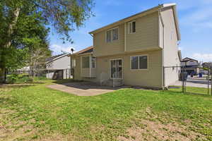 Rear view of property featuring a gate, a fenced backyard, and a patio