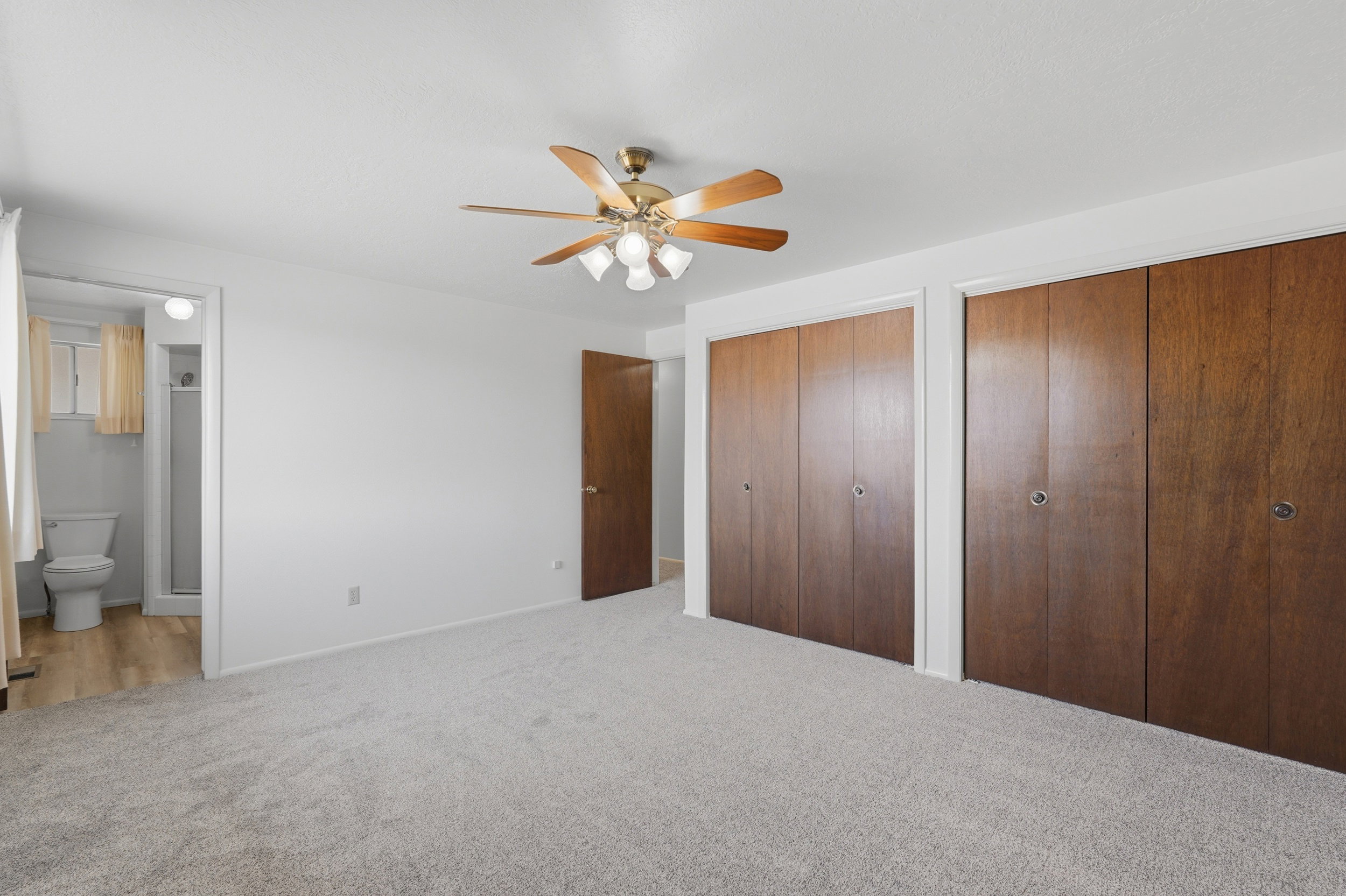 Spacious room featuring light-toned carpeting and a ceiling fan with integrated lighting