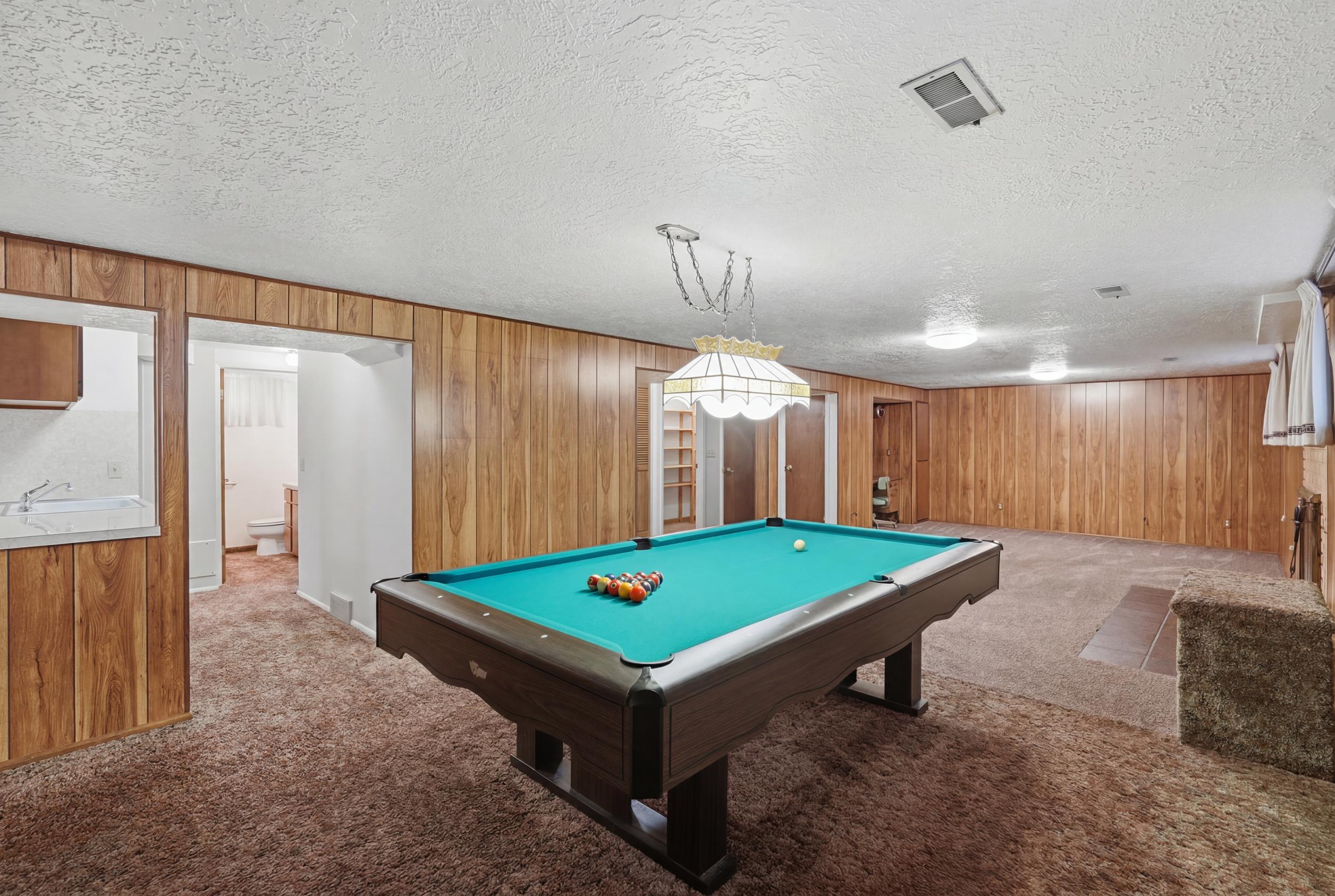 Recreation room featuring wood-finish wall paneling, recessed lighting, and carpet flooring and included pool table.