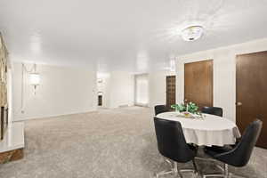 Open-concept living area featuring light-toned carpeting and neutral wall colors