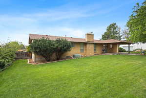 Rear view of property featuring a chimney