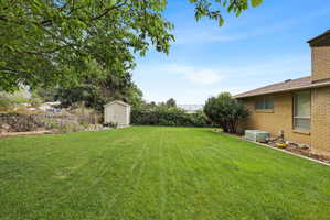 Fenced backyard featuring a storage shed