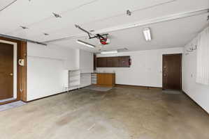 Garage with baseboards and a garage door opener
