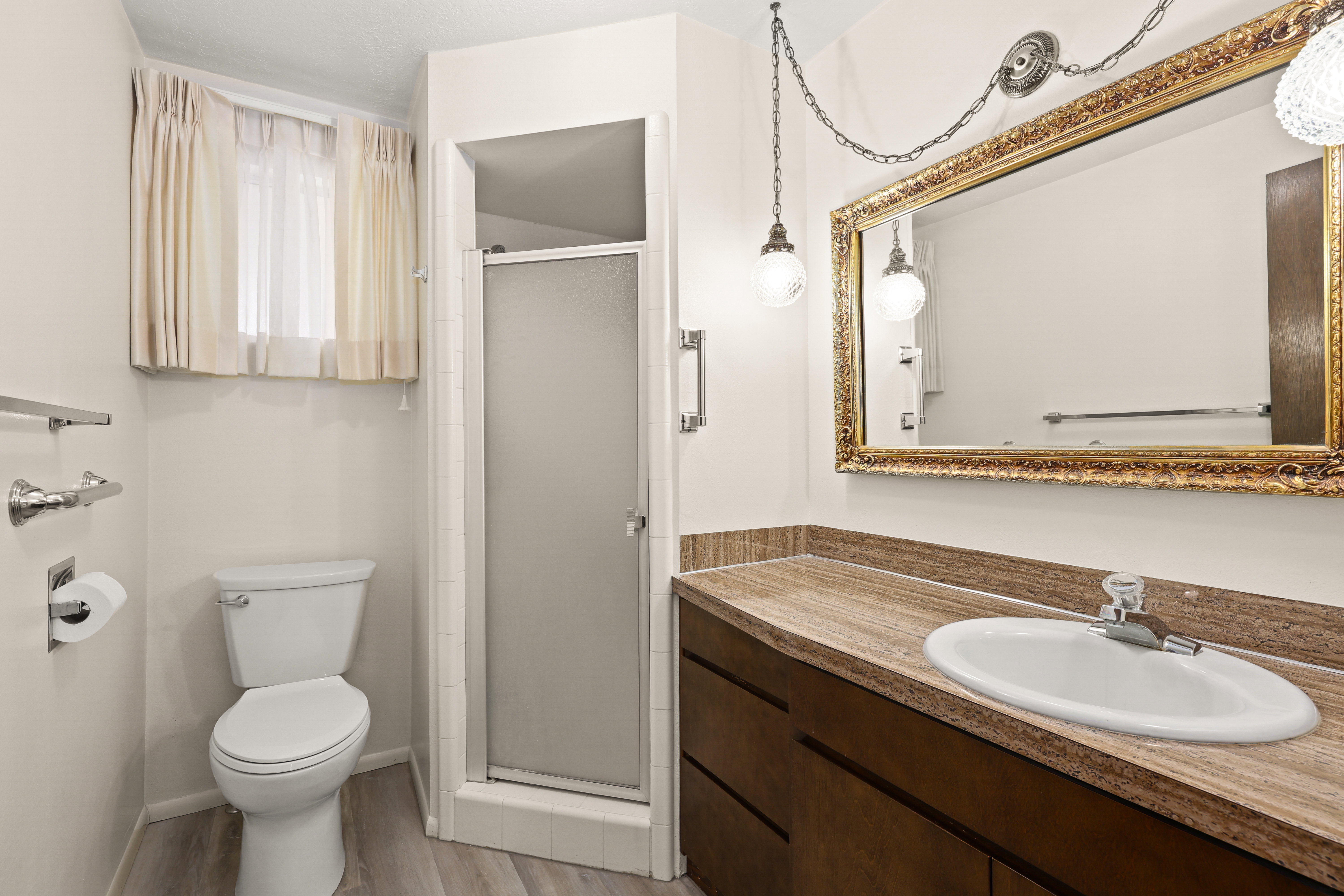 Bathroom featuring a built-in wood-finish vanity with a light-toned countertop and an undermount sink