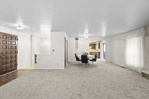 Interior space featuring a textured ceiling, carpet floors, and suspended lighting
