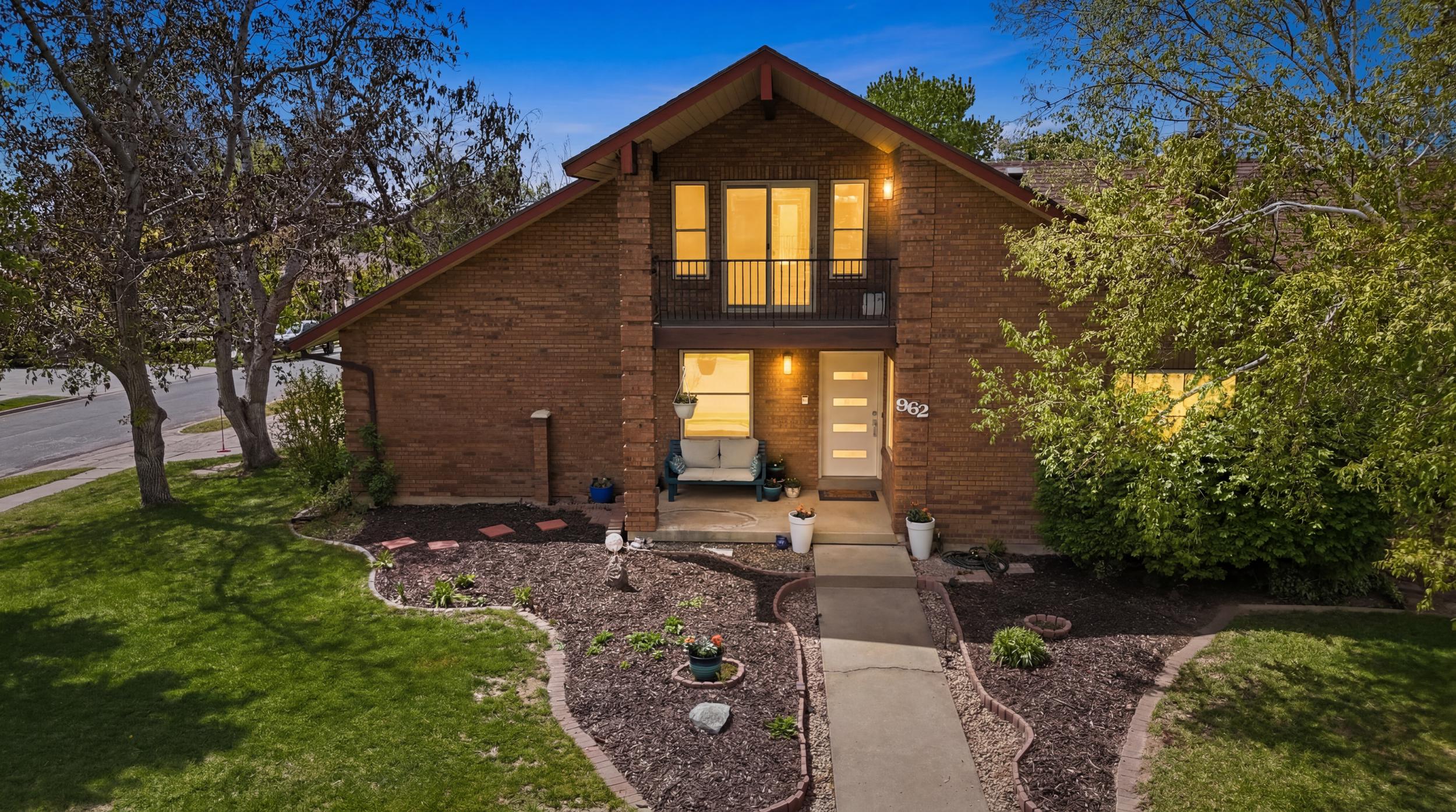 Brick exterior residence featuring a gabled roofline and an upper-level balcony