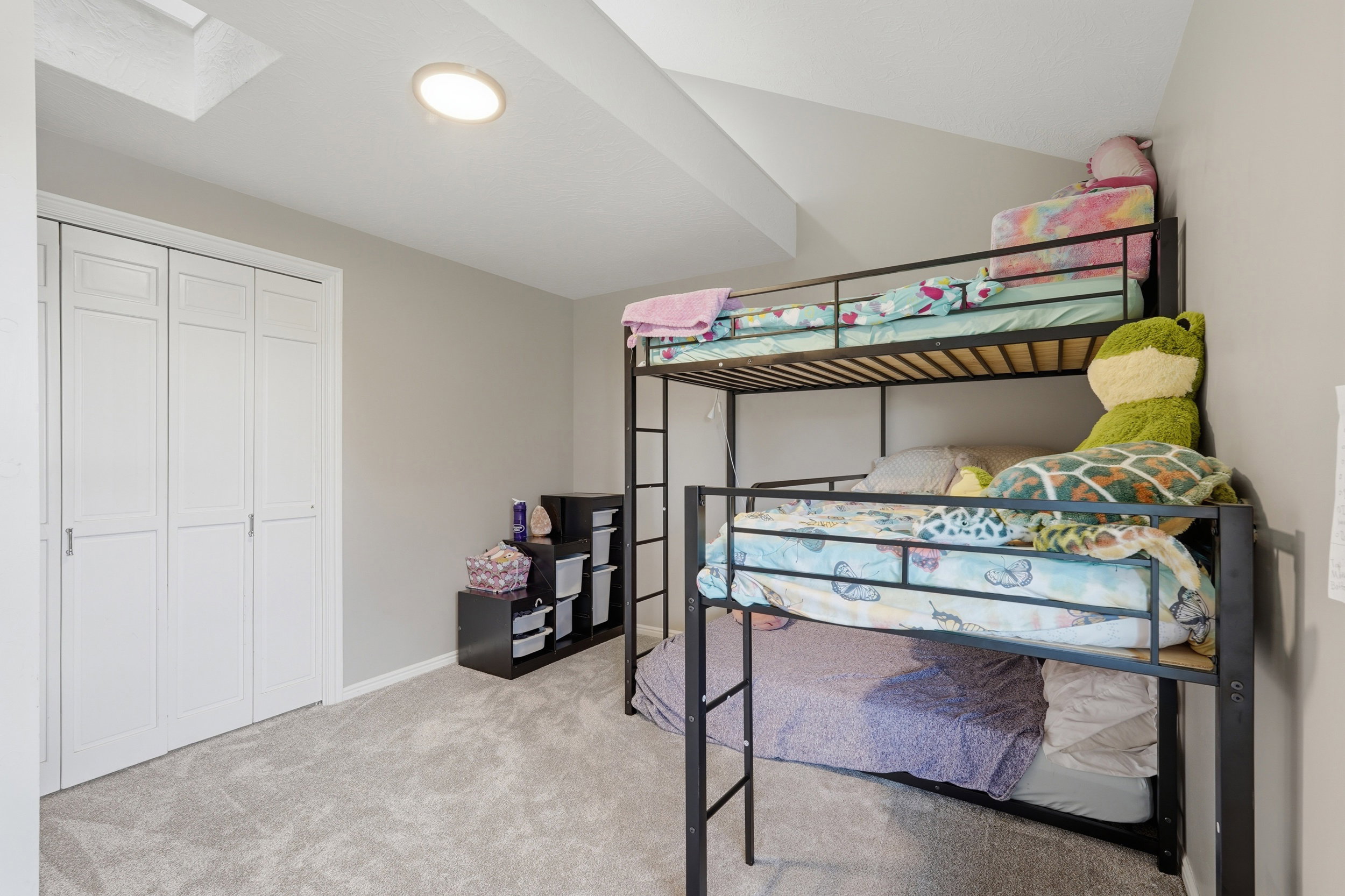 Bedroom featuring light carpet, Loft space above, vaulted ceiling, and a closet
