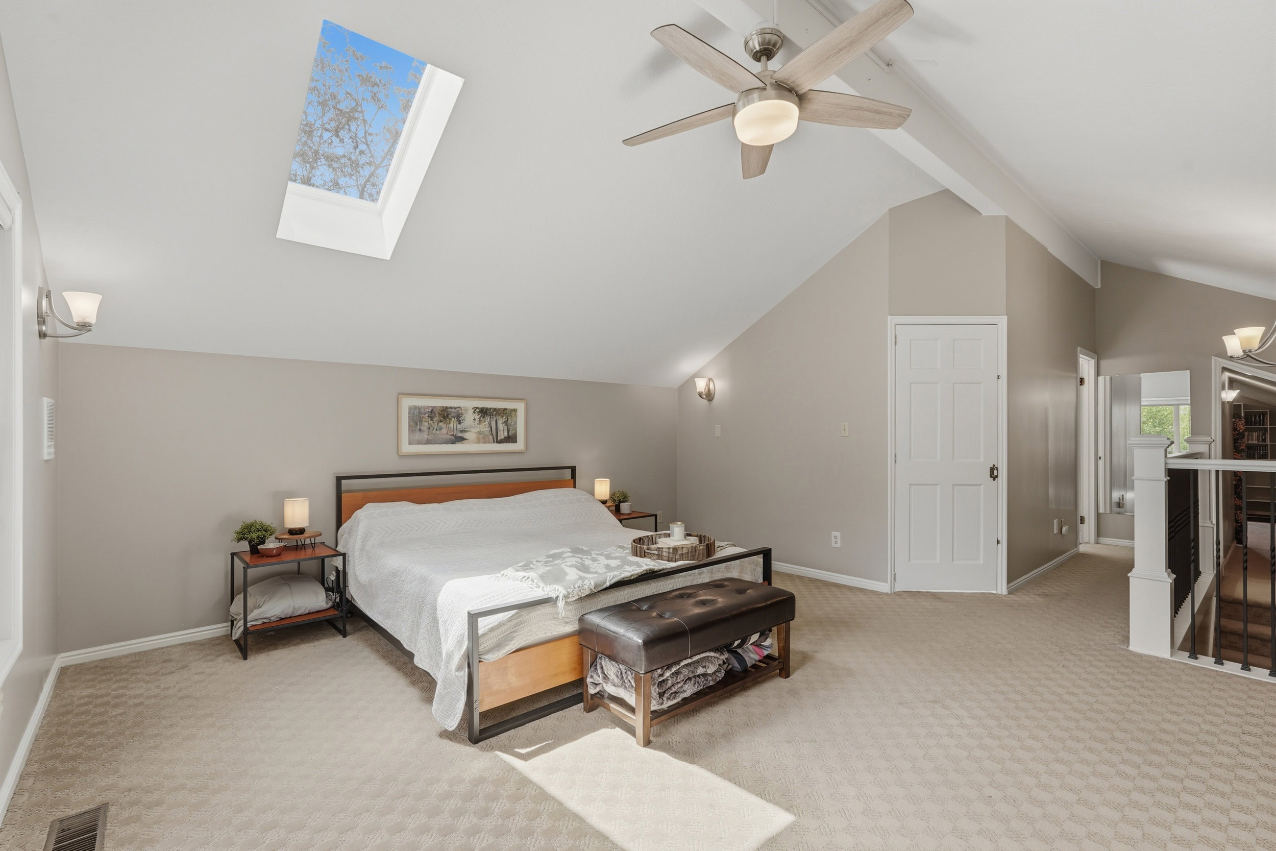 Primary Bedroom featuring a skylight, access to exterior balcony.