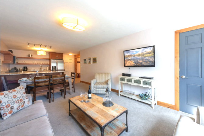 Living room with light colored carpet and track lighting
