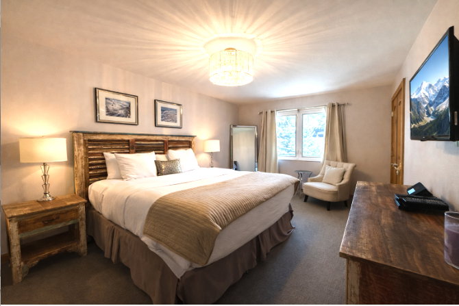 Bedroom featuring dark colored carpet and suspended lighting
