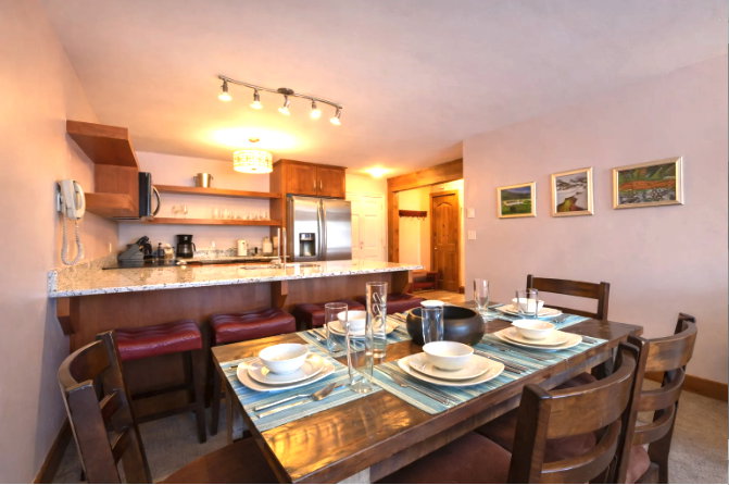 Dining room with track lighting and dark colored carpet