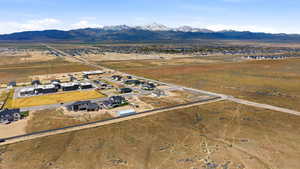 Aerial view of property and surrounding area with mountains, nearby suburban area, and rural landscape
