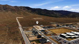 Aerial view of property and surrounding area featuring a mountain backdrop and rural landscape