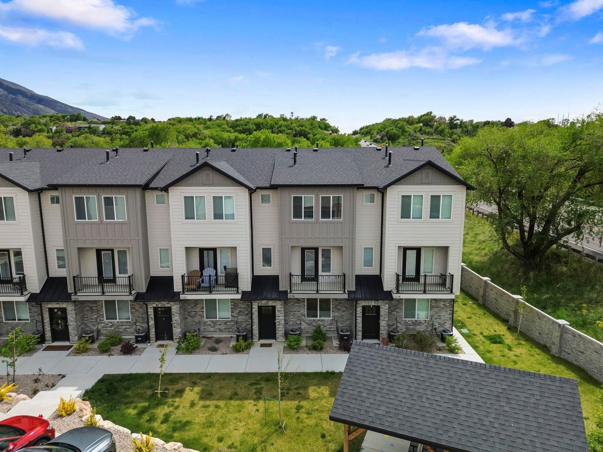 Back of property featuring a balcony, board and batten siding, and stone siding