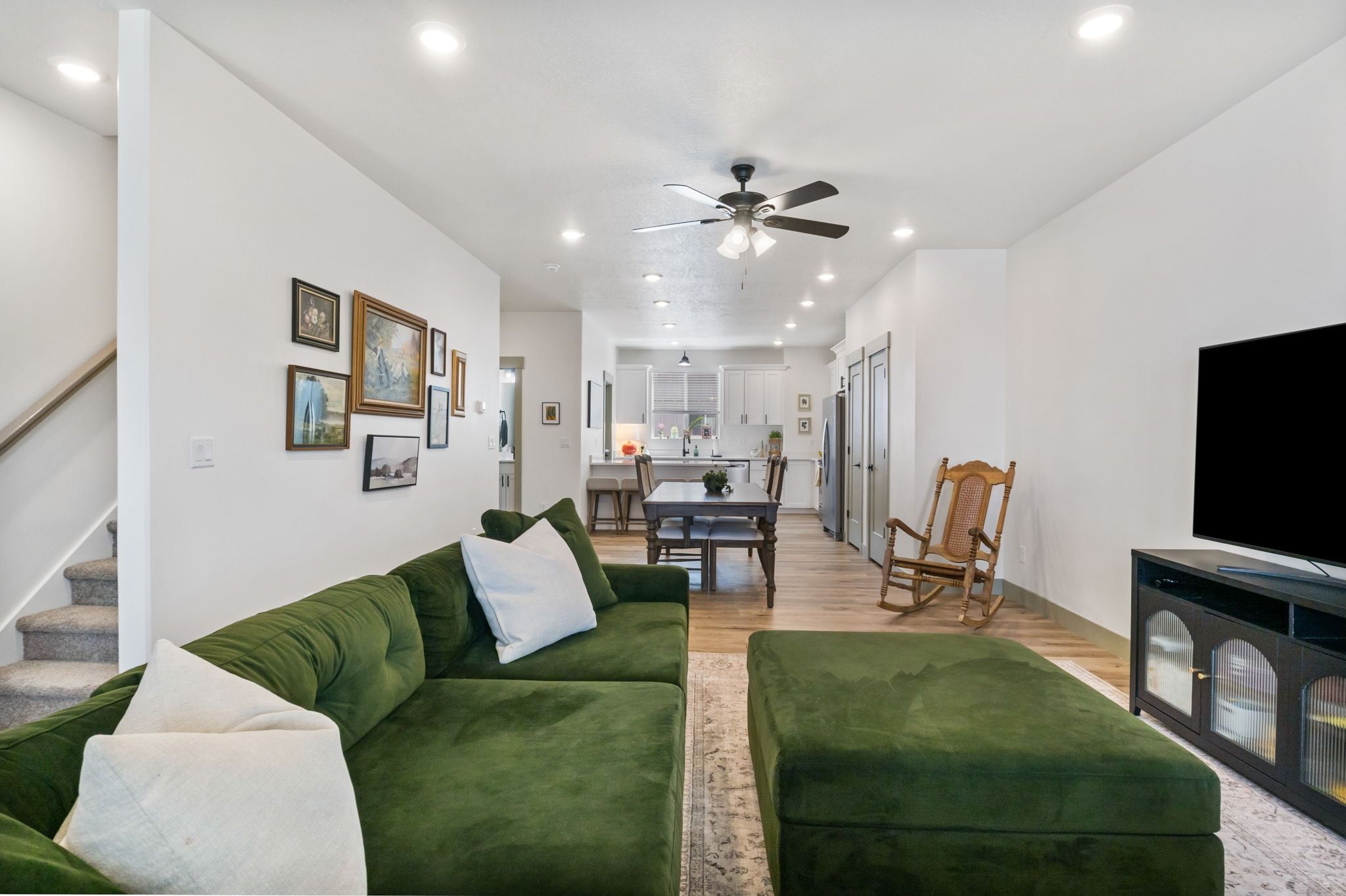Living area with light wood finished floors, a ceiling fan, and recessed lighting