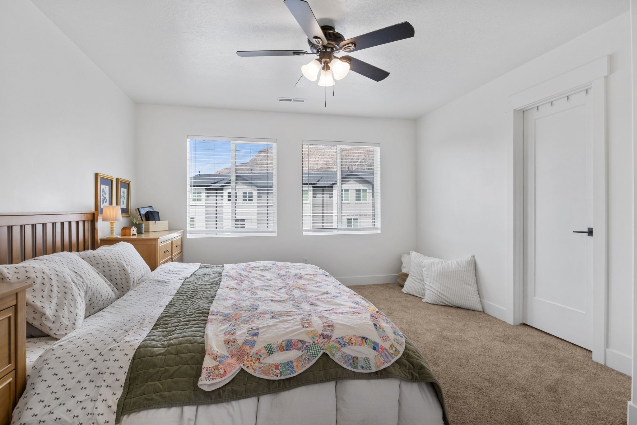 Carpeted bedroom featuring ceiling fan and baseboards