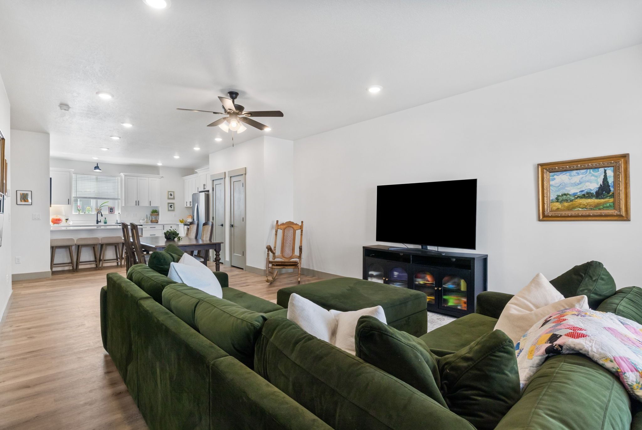 Living area with light wood-type flooring, a ceiling fan, and recessed lighting