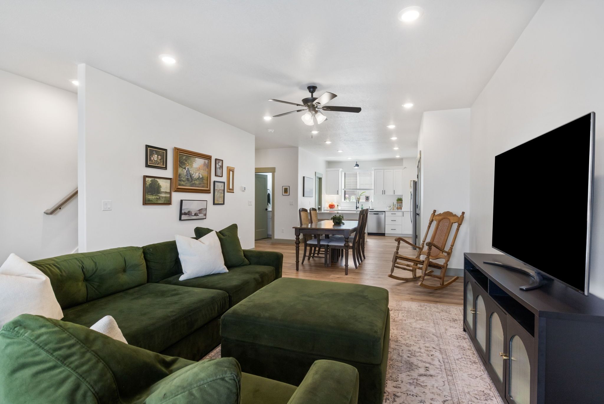 Living area with light wood-style floors, ceiling fan, and recessed lighting