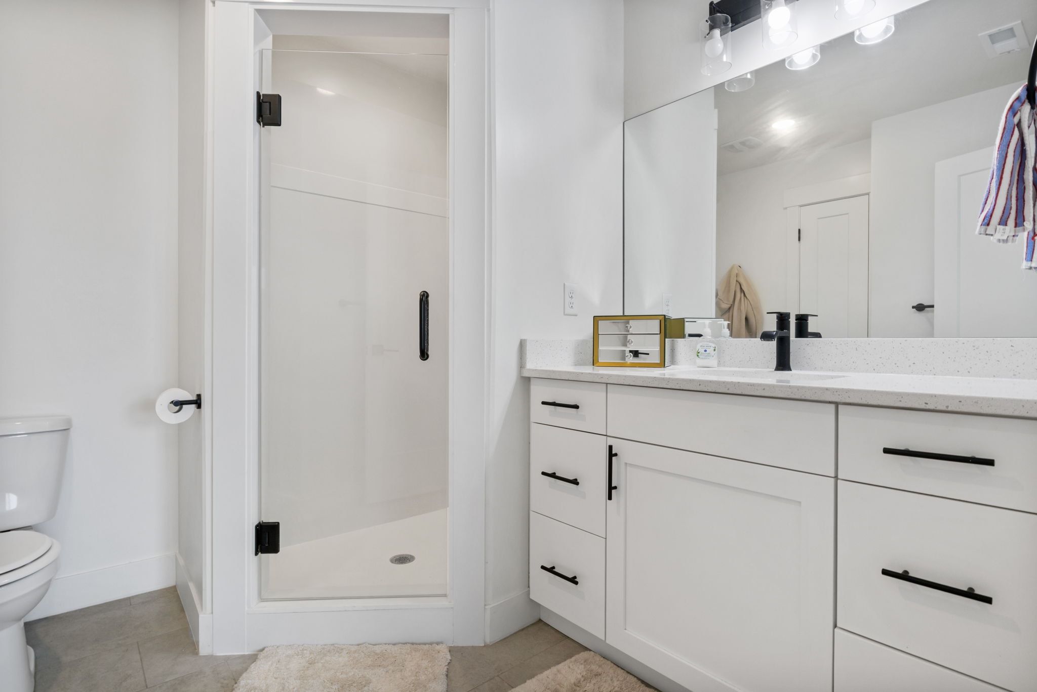 Full bath with vanity, a stall shower, and light tile patterned floors