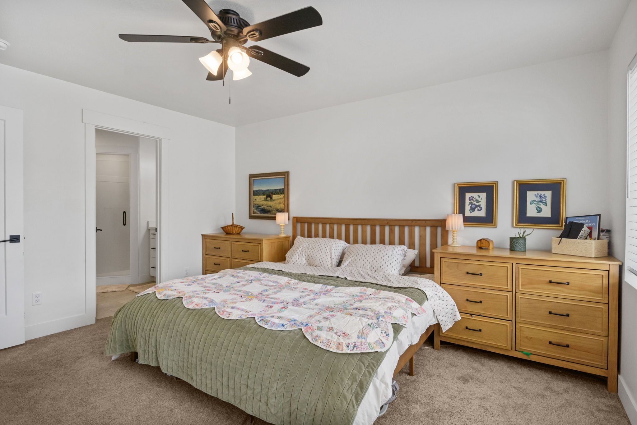 Bedroom featuring connected bathroom, light carpet, and ceiling fan