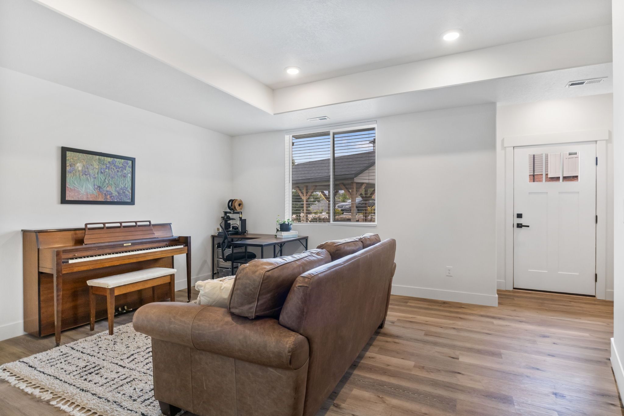 Living area featuring light wood finished floors, recessed lighting, and a tray ceiling