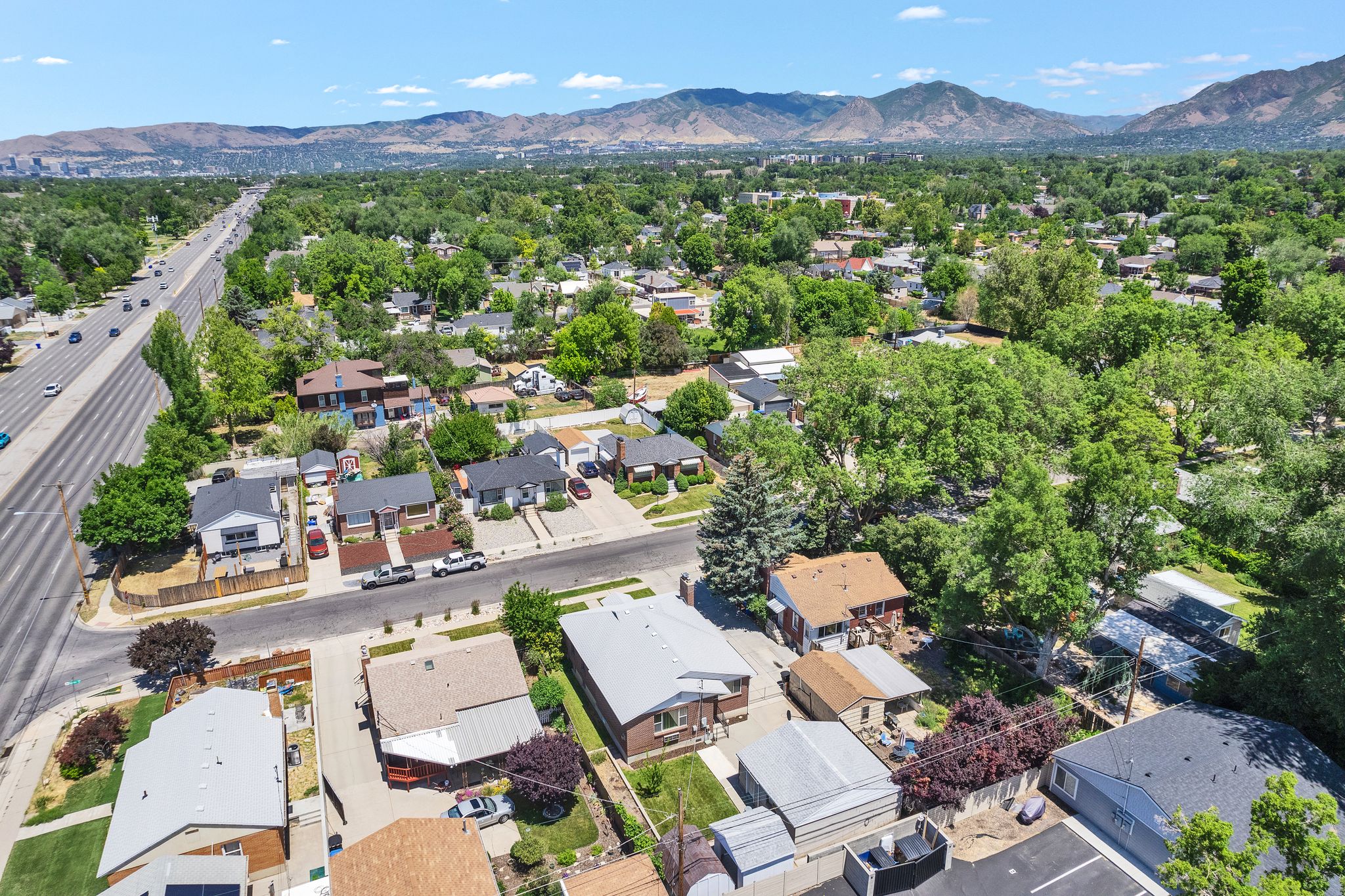 Residential neighborhood featuring a prominent multi-lane thoroughfare and distant mountain range