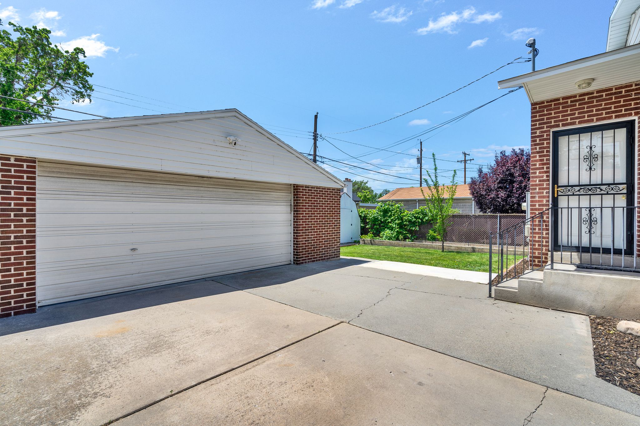 Detached garage with a white overhead door, brick facade, and white soffit and fascia
