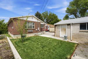 Back of house featuring a yard and brick siding