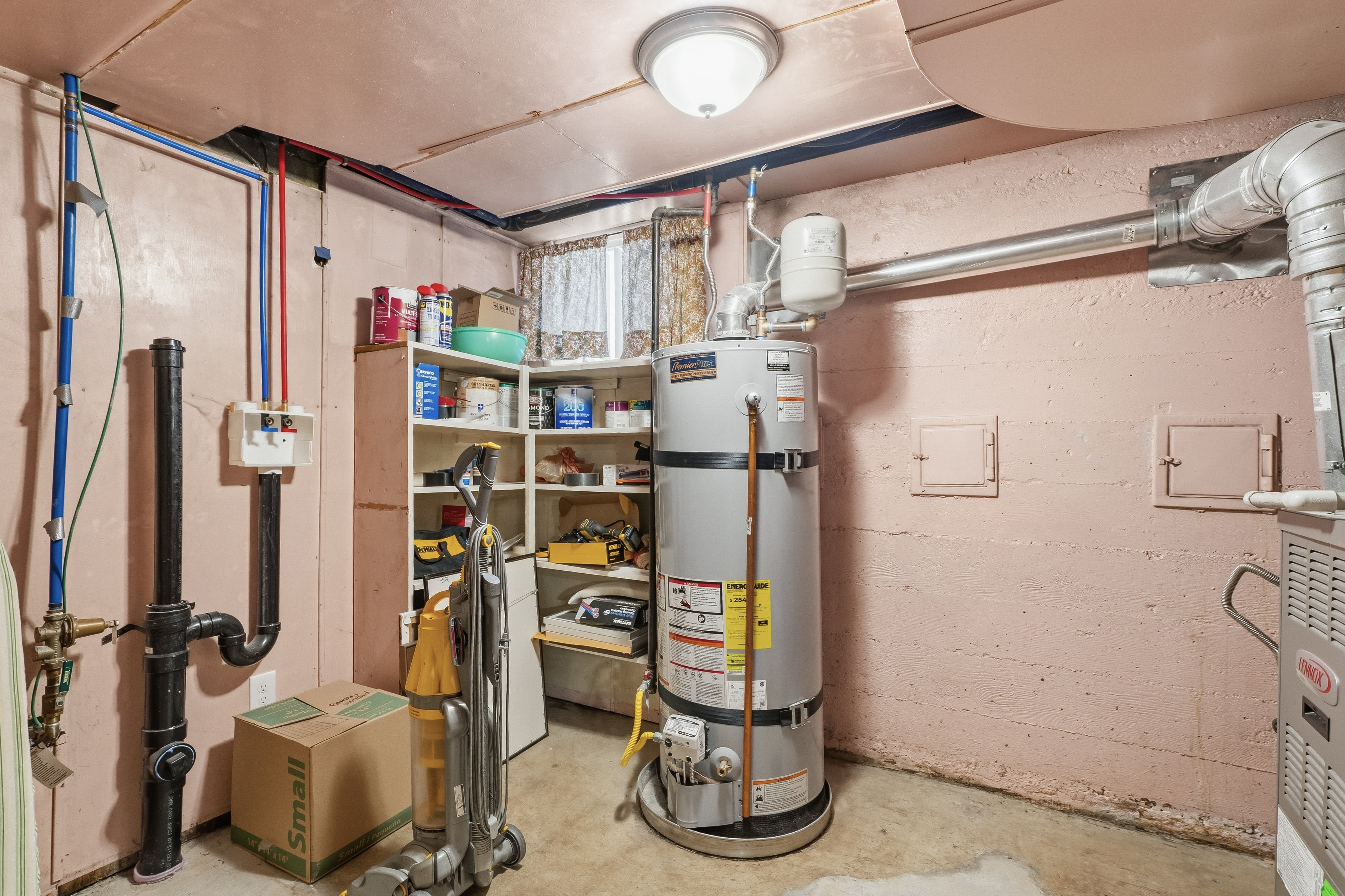 Utility room featuring secured water heater and heating unit