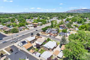 Residential neighborhood with mature trees, established properties, and a visible mountain range in the distance