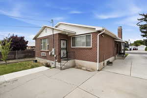 Bungalow-style home with brick siding and a chimney