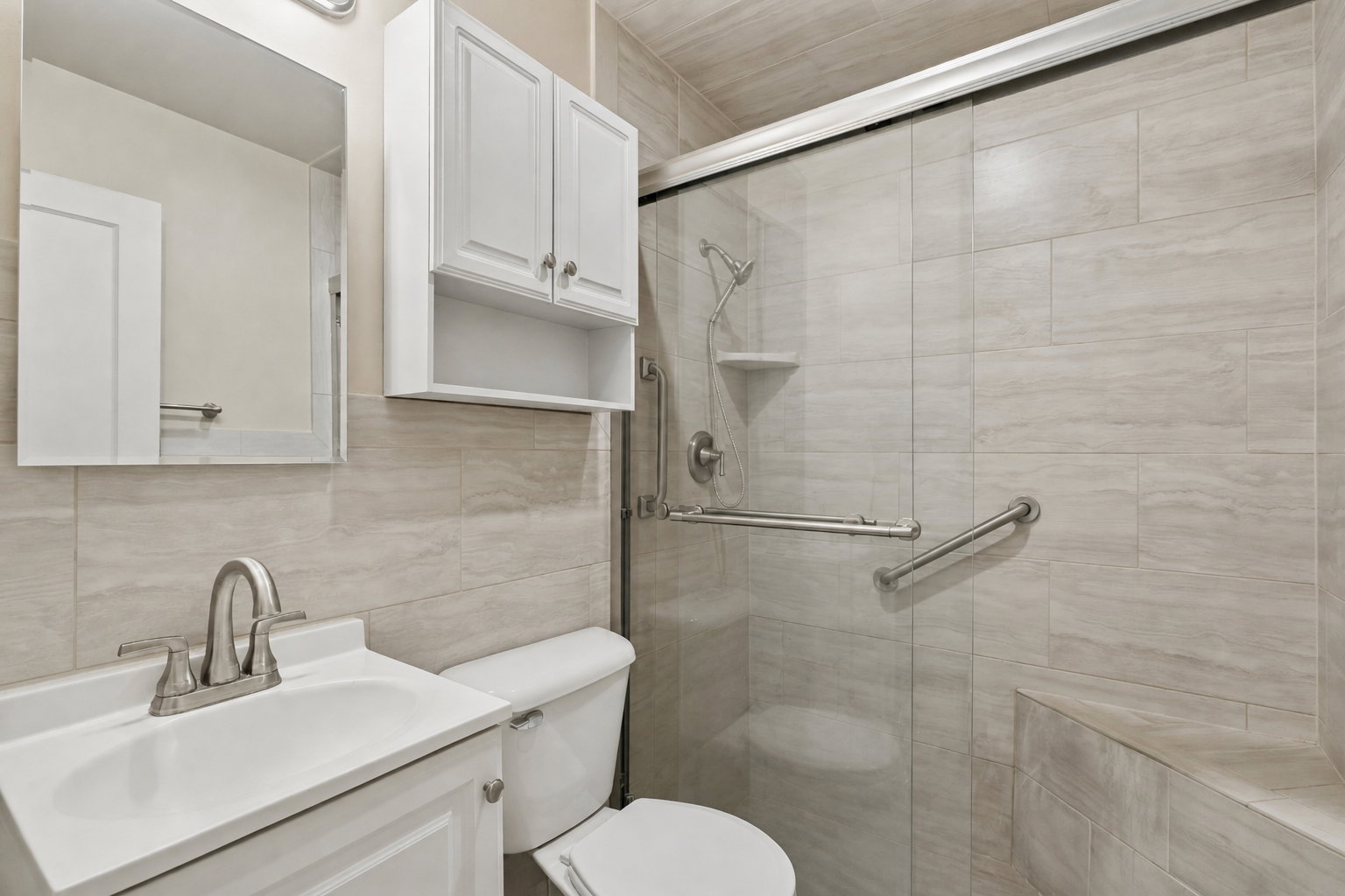 Full bath featuring vanity, tile walls, and a shower stall