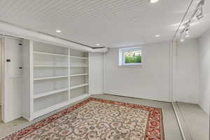 Basement featuring track lighting