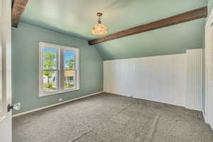 Bonus room featuring vaulted ceiling with beams and carpet floors