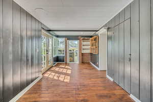 Corridor with wooden walls and hardwood / wood-style floors