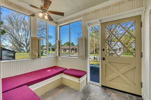 Unfurnished sunroom with a ceiling fan