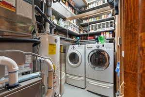 Laundry area featuring heating unit, water heater, finished concrete flooring, and separate washer and dryer