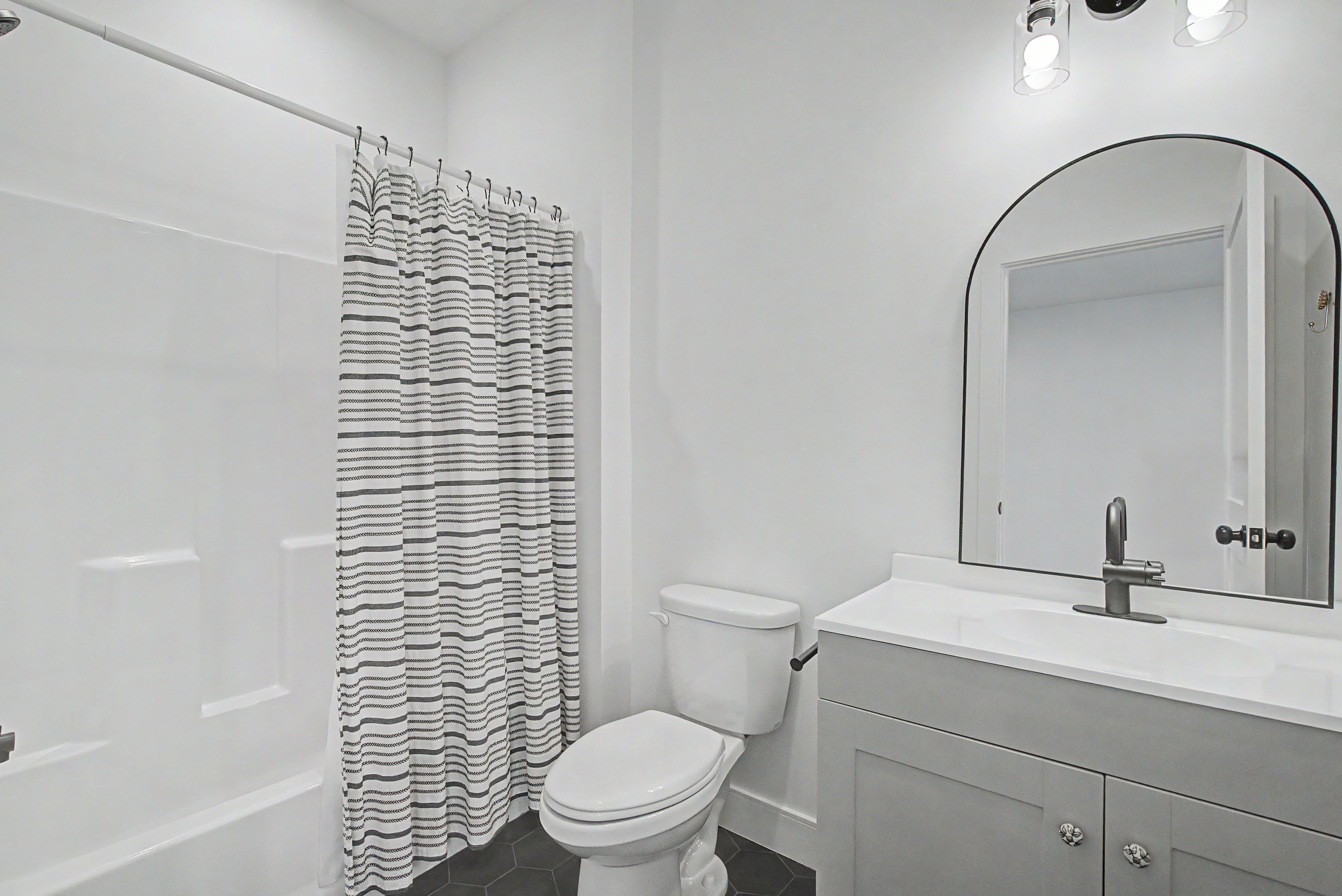 Full bathroom featuring vanity, shower / tub combo, and dark tile patterned flooring