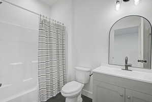 Full bathroom featuring vanity, shower / tub combo, and dark tile patterned flooring